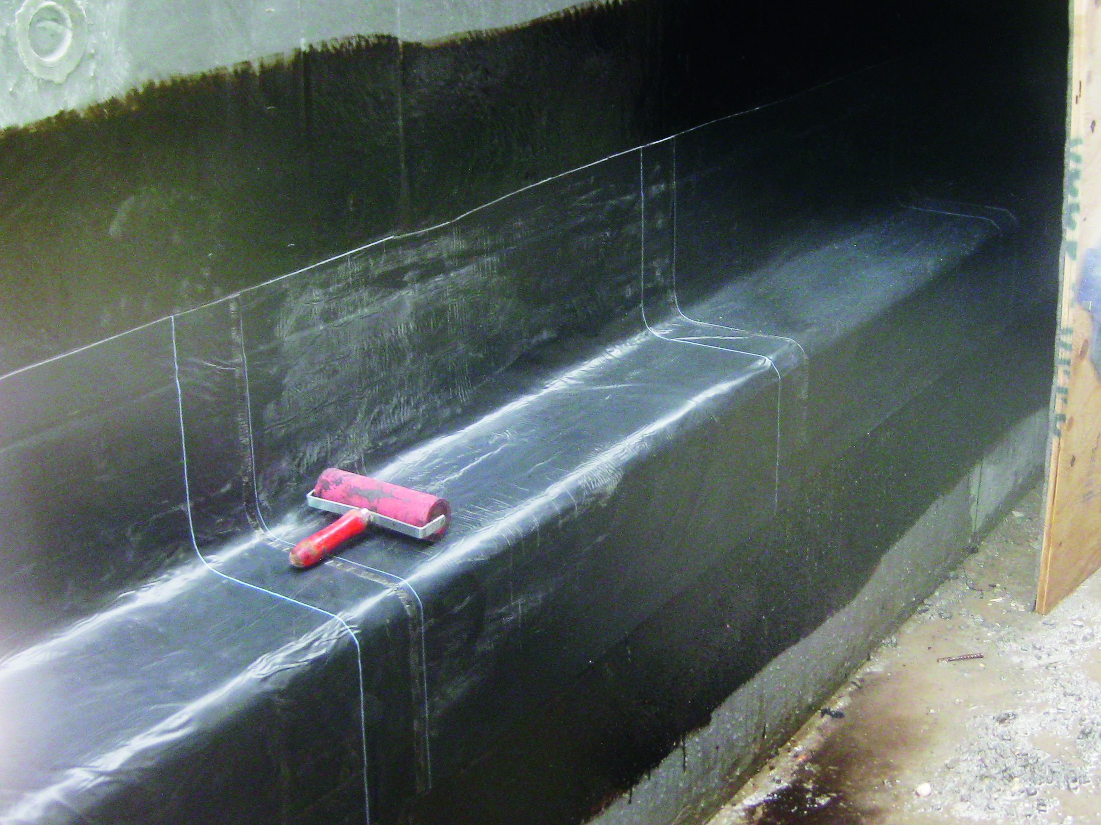 Figur 52 viser tætning mellem kældervæg og betonbundplade udført med koldmonteret membran. 